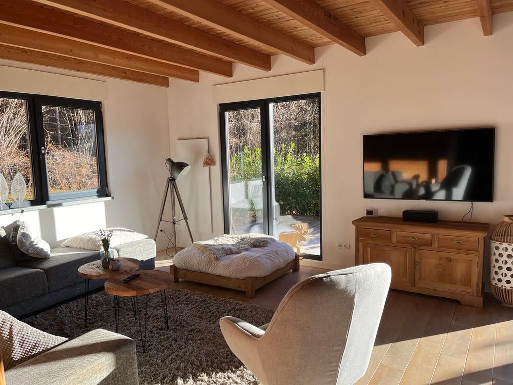 Chalet Presseggersee comfortabele woonkamer met hoekbank, eettafel met 10 stoelen, smart TV, houtkachel